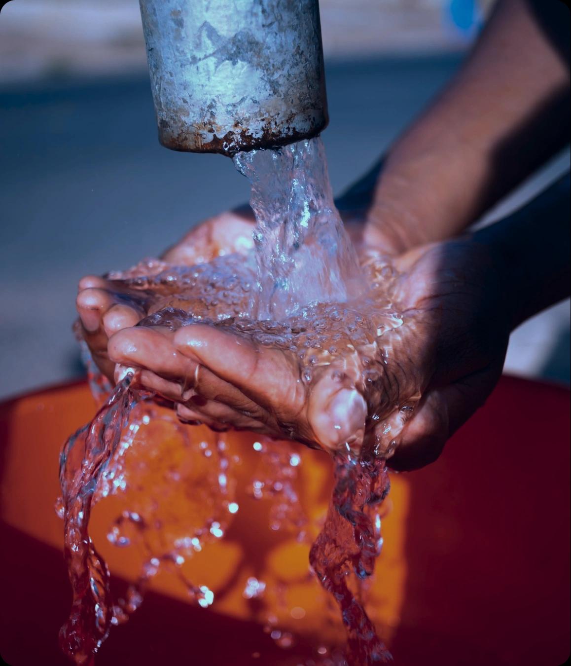 Water flowing from a tap over hands